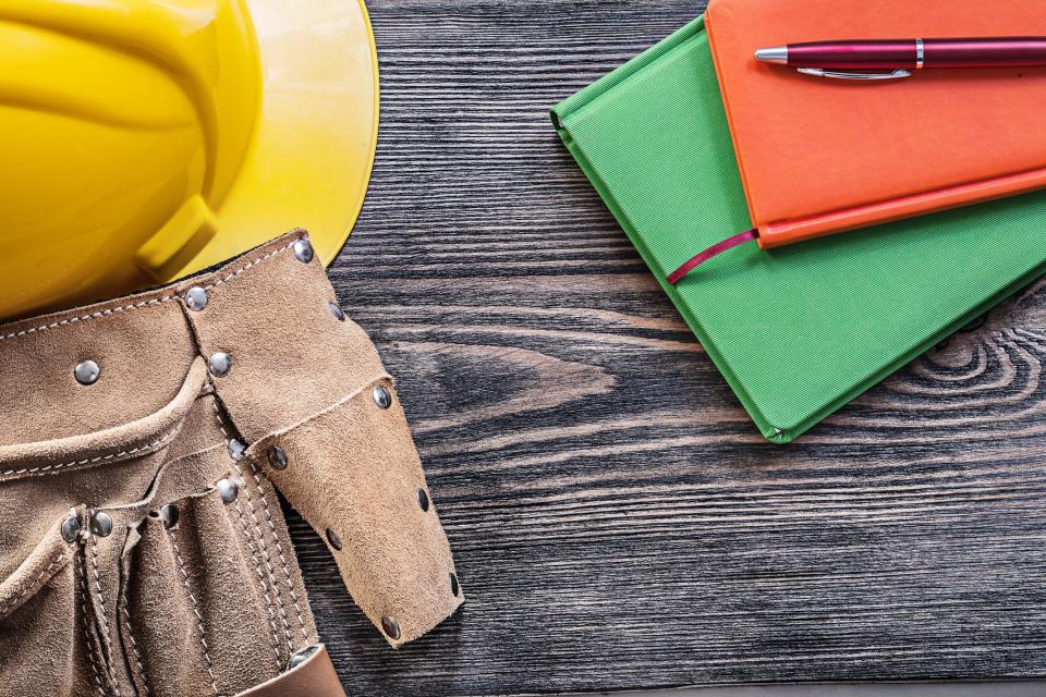 Hardhat and Tool belt on Table with Note Pads