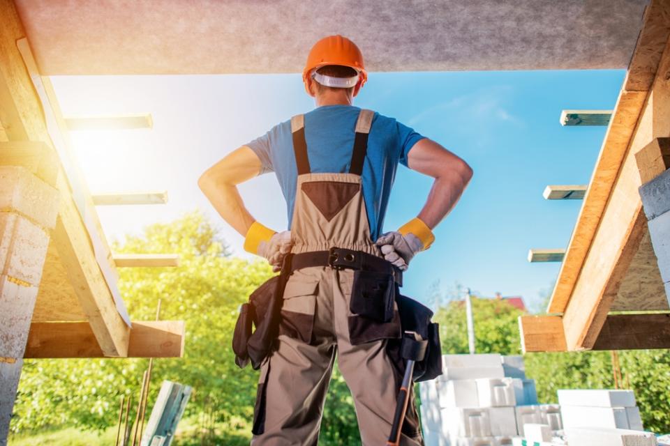 Builder standing in a power pose at a build site